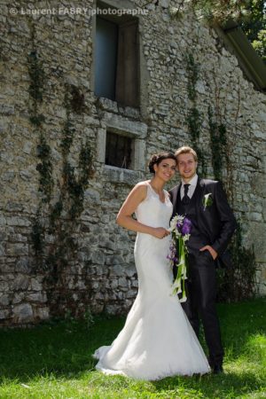 les mariés posent près du mur en pierre, mariage au Château de Boigne, photographe Chambéry, Savoie