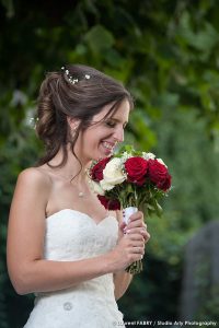 Photographe de mariage en Savoie : fou rire de la mariée tenant son bouquet