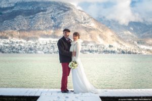 Photographe mariage Haute Savoie : Mariés sur un ponton enneigé sur le lac d'Annecy