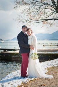 Les mariés posent sur la piste cyclable autour du lac d'Annecy (mariage en hiver)