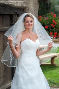 Photographe de mariage en Haute Savoie : portrait de la mariée tenant son voile