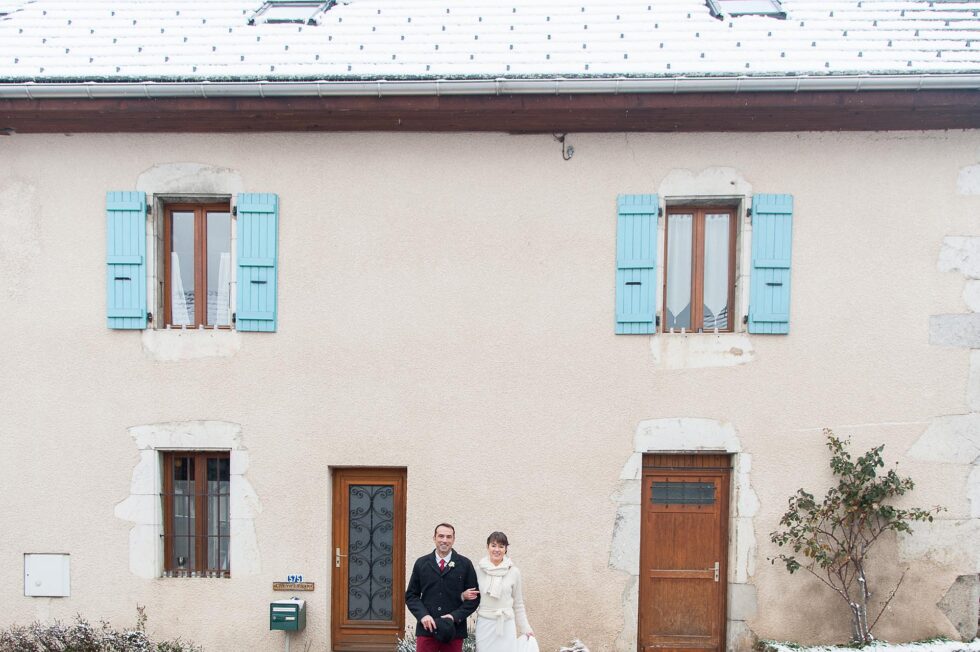 les mariés posent devant leur maison, photographe de mariage près du lac d'Annecy (74)