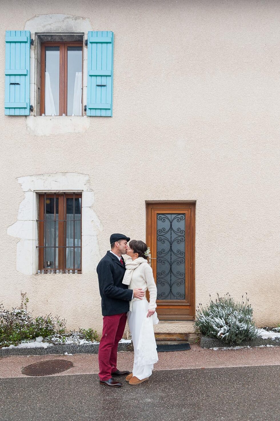 les mariés s'embrassent devant leur maison, photographe de mariage près du lac d'Annecy (74)