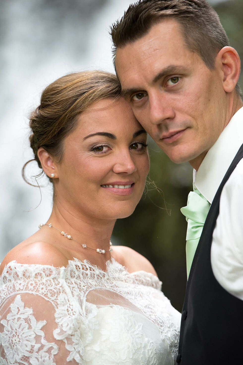 portrait serré des mariés devant la cascade, photographe de mariage en Savoie