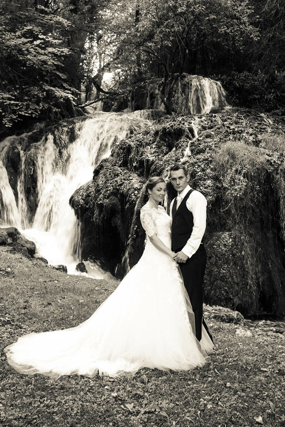 portrait des mariés devant la cascade, noir et blanc, photographe de mariage en Savoie