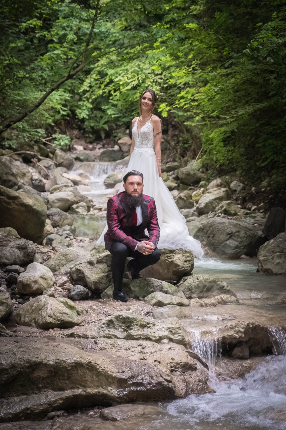 Photographe de mariage en Isère : les mariés posent dans le ruisseau ombragé dans la forêt