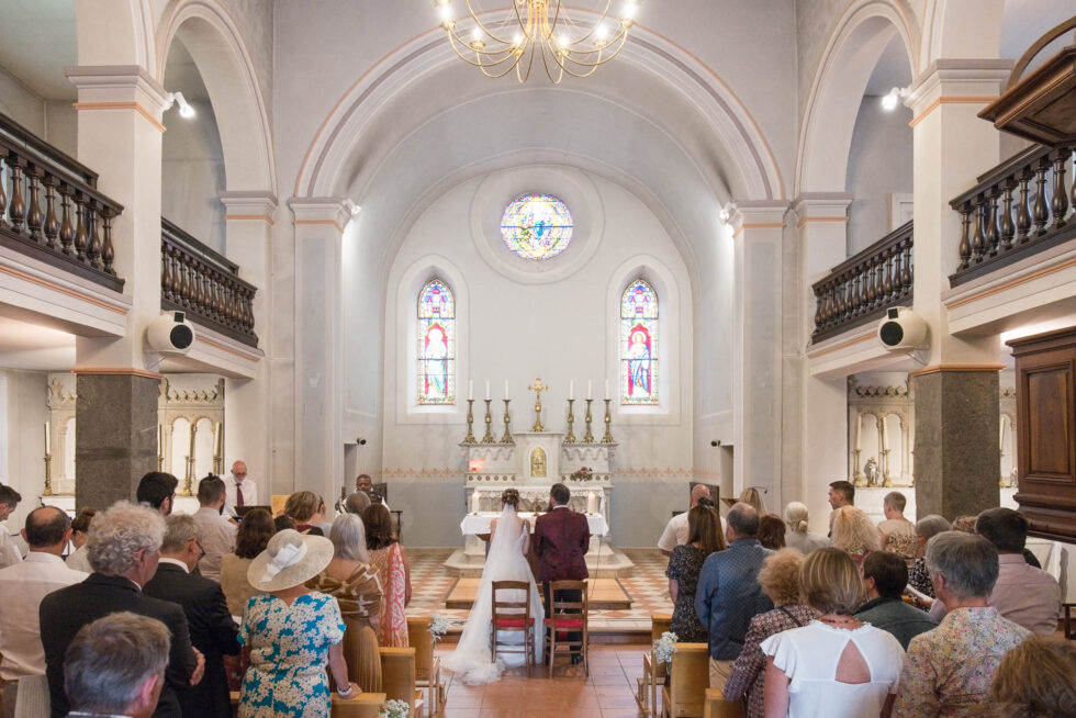 Photographe de mariage en Isère : les mariés de dos et l'allée centrale pendant la cérémonie