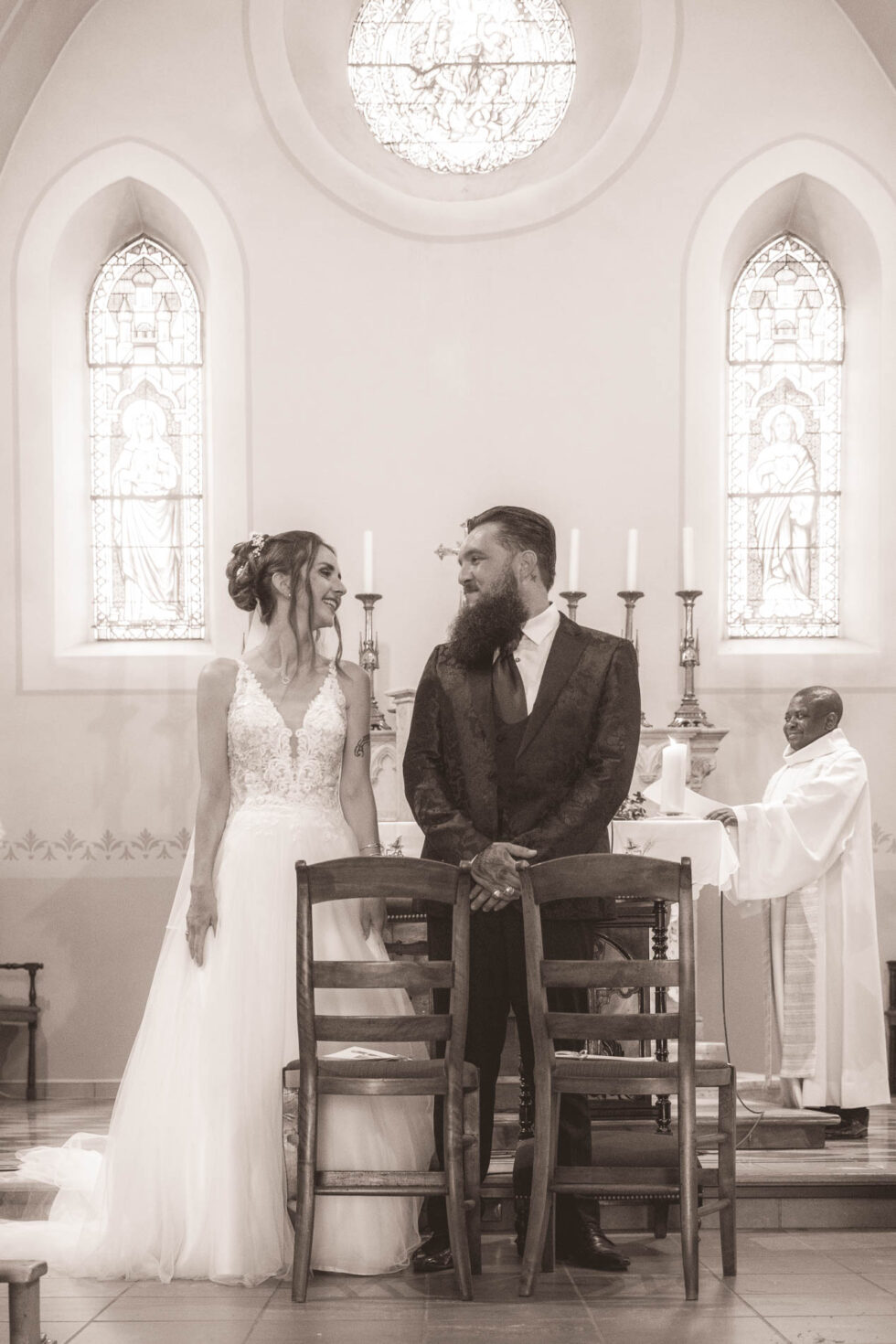 Photographe de mariage en Isère : regard complice entre les mariés à l'église de Bernin