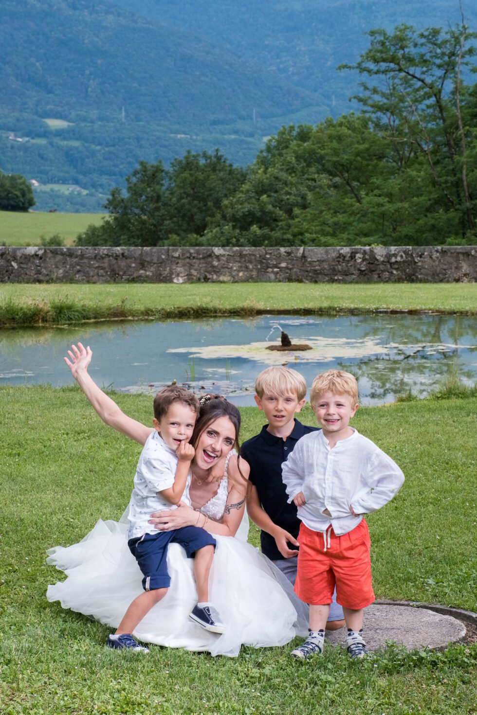 Photographe de mariage en Isère : la mariés pose avec des enfants de la famille