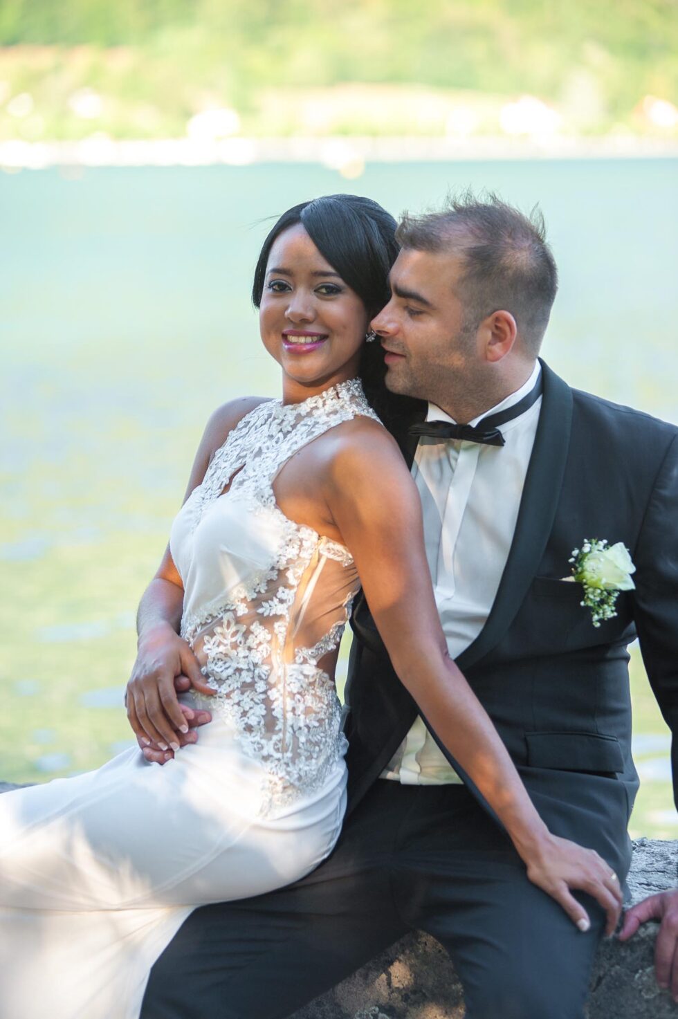 Photographe de mariage à Annecy : pose assise des mariés sur le ponton de l'Imperial Palace