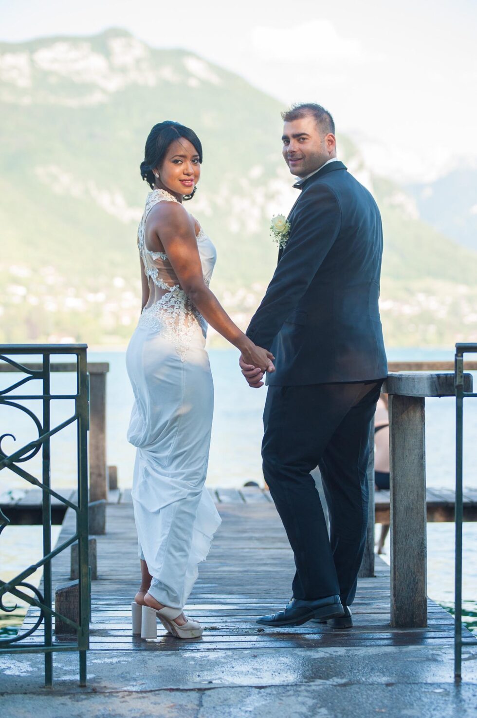 Photographe de mariage au lac d'Annecy : les mariés se retournent sur le ponton de l'Imperial Palace