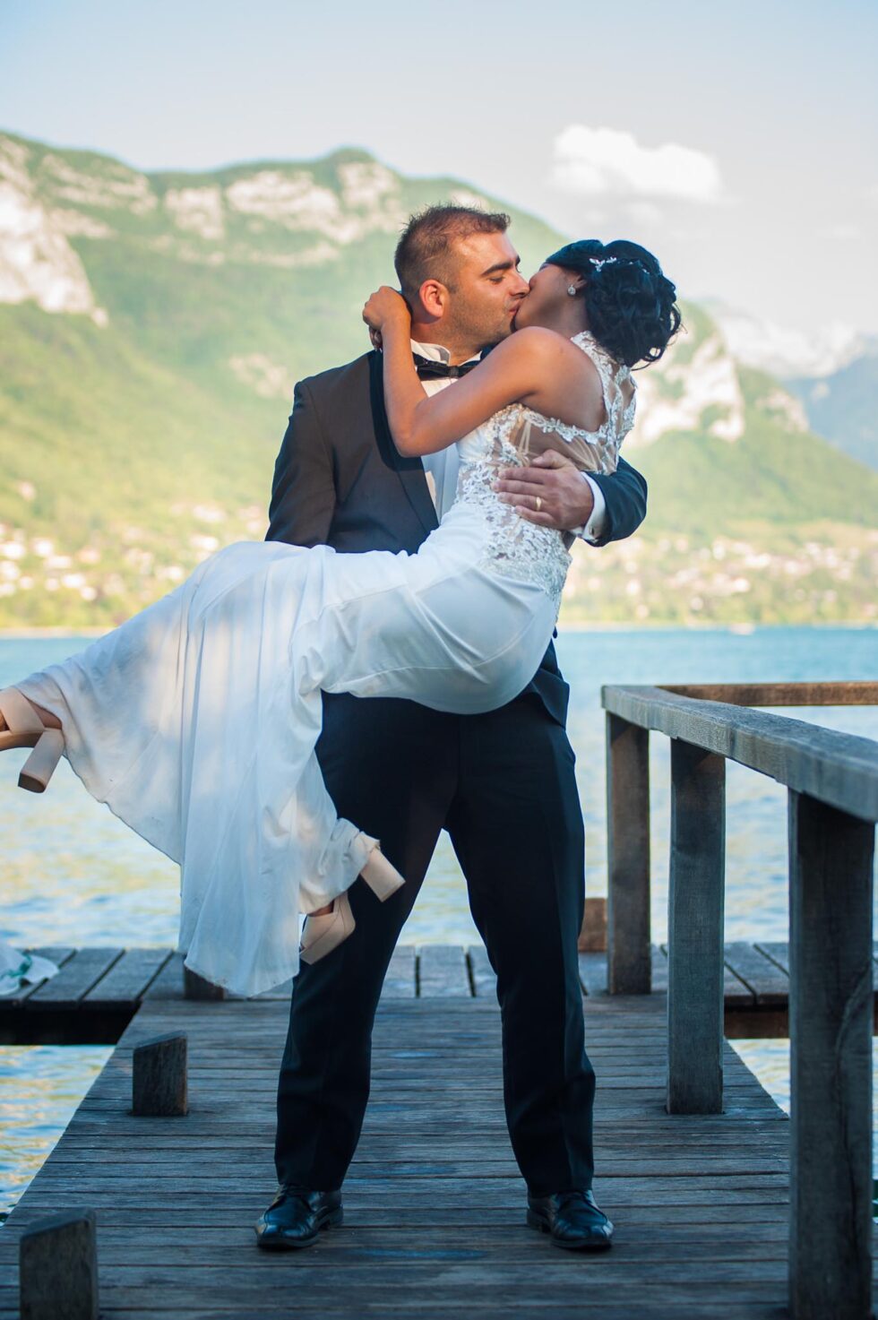Photographe de mariage au lac d'Annecy : pose romantique des mariés sur le ponton de l'Imperial Palace