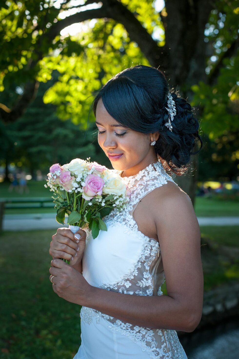 Photographe de mariage à Annecy : portrait de la mariée sous les arbres ensoleillés de l'Imperial Palace, en sépia