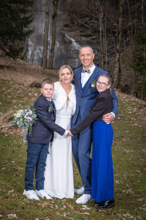 Photographe de mariage à la montagne : photos de famille devant une cascade