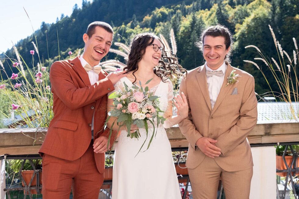 Reportage de mariage en automne à la montagne : photo de la mariée et ses frères sur la terrasse de la mairie