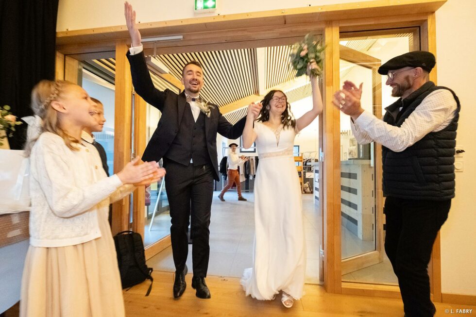 Reportage de mariage en automne à la montagne : entrée des mariés dans la salle des fêtes