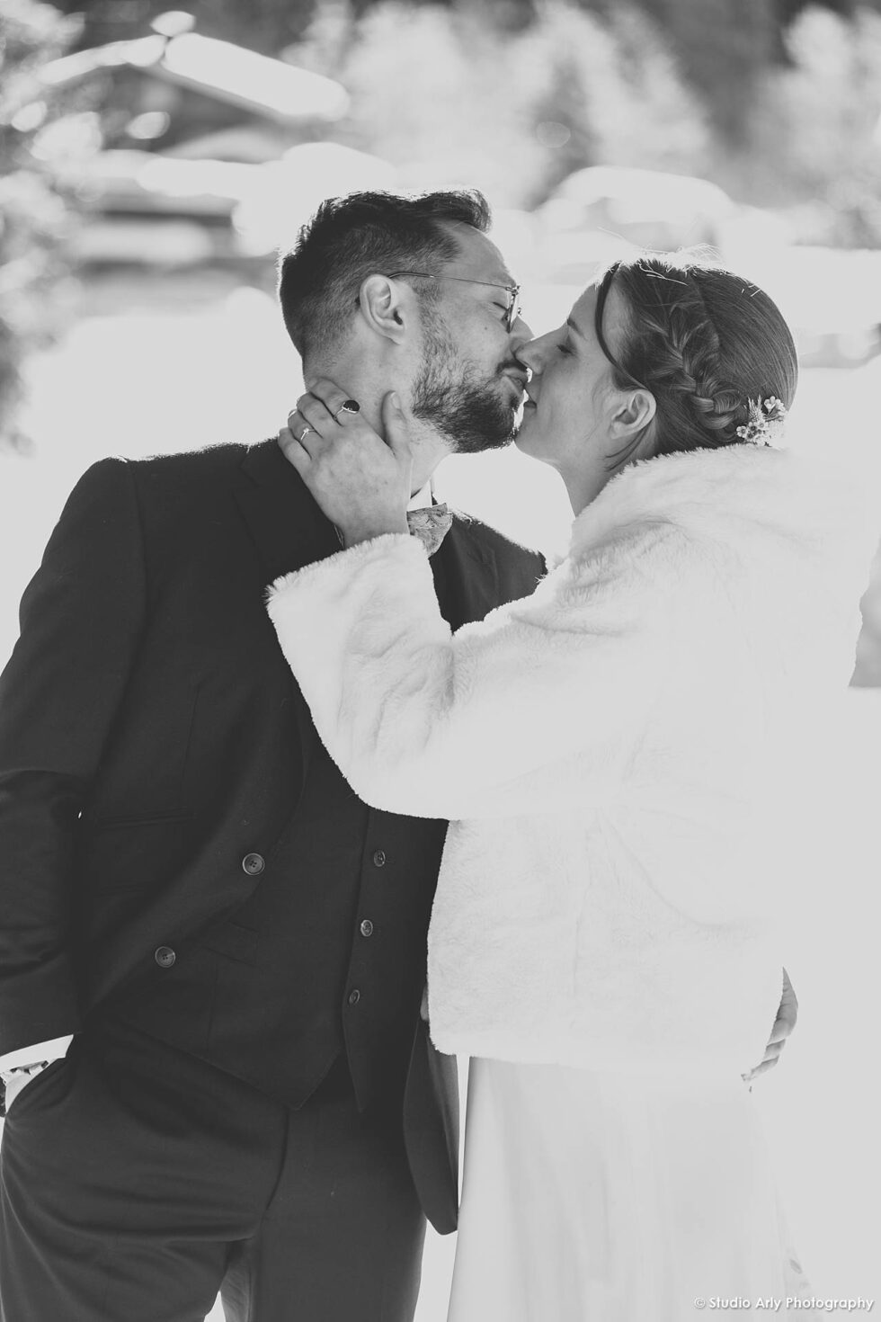 Mariage en hiver à la Giettaz : échange de baiser des mariés en noir et blanc