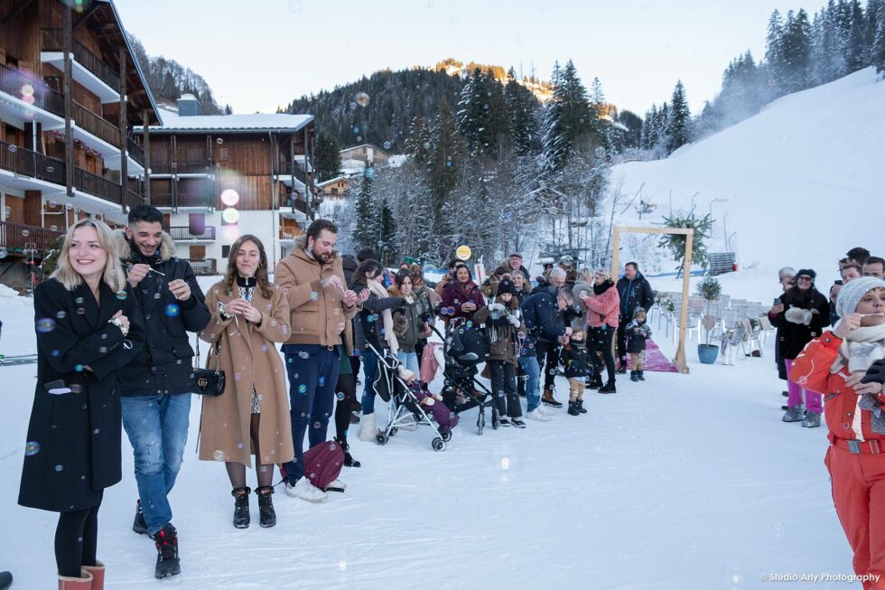 Cérémonie laïque dans la neige à la montagne : haie d'honneur des invités au pied de la piste de ski