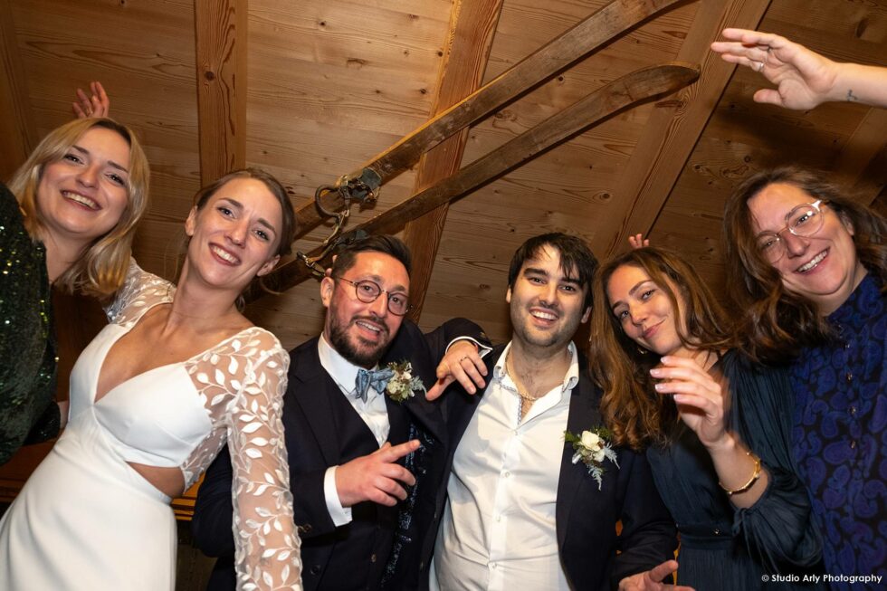 mariage à la montagne en hiver : portrait des mariés et leurs invités dans un chalet