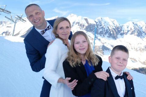 Photographe de mariage à la montagne : pose en famille dans la neige
